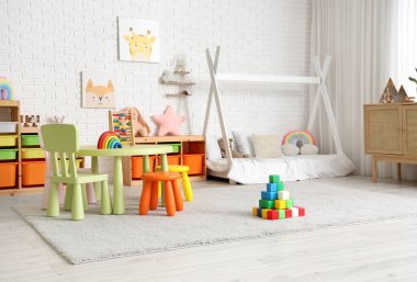 Yatak odası, yatak, masa ve oyuncaklar.