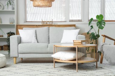 Kanepesi, çiçekleri ve şık kahve masası olan modern oturma odasının içinde.