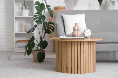 Kanepesi, çiçekleri ve şık kahve masası olan modern oturma odasının içinde.