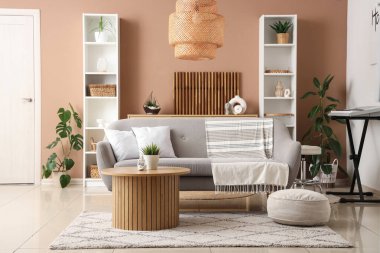 Kanepesi, rafları ve bej duvarın yanındaki şık sehpası olan modern oturma odasının içinde.