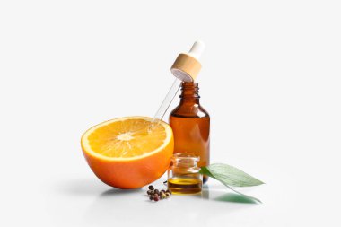 Portakal yağı şişeleri ve gri arka planda karabiber.