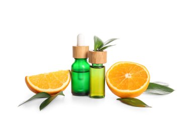 Beyaz arka planda taze meyve ve yapraklarla portakal yağı şişeleri