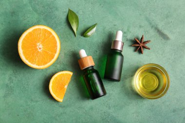 Şişeler ve cam kase portakal yağı yeşil arka planda yıldız anasonu