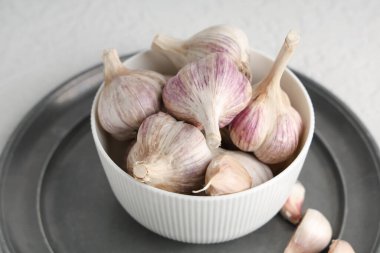 Beyaz arka planda taze sarımsaklı kase, yakın plan.