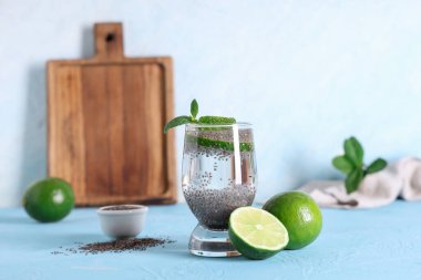 Mavi grunge arka planında Chia tohumlu, limonlu ve naneli bir bardak su.