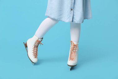 Mavi arka planda buz patenli kız bacakları