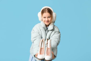 Mavi arka planda buz pateni yapan tatlı bir kız.