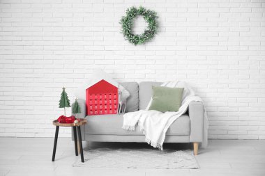 Oturma odasının içinde kanepe, masa ve Noel takvimi var.