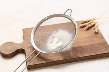 Un, ahşap tahta ve arka planda çivili metal elek.