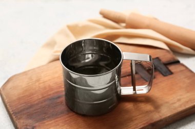 Tahta tahta tahta tahta, metal elek kupası, yuvarlak raptiye ve hafif arka planda peçete