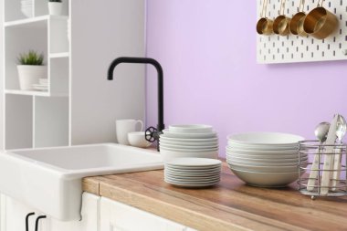 Temiz tabaklar ve kaseler şık mutfaktaki lavabonun yanında, yakın plan.