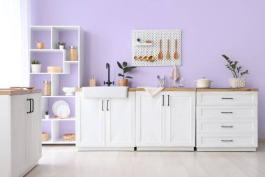 Ahşap kaplamalı, raflı ve ev bitkilerli şık bir mutfak.