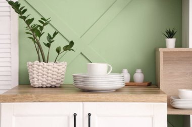 Mutfaktaki ahşap tezgahta temiz tabaklar ve fincanlar, yakın plan.