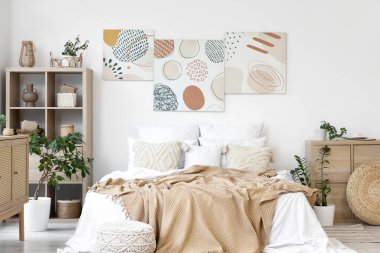 Şık yatak odaları, rahat yataklar, ev bitkileri ve güzel tablolar.