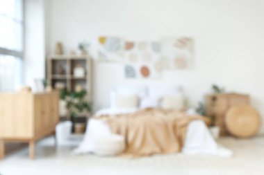 Şık yatak odası, rahat yatak, ev bitkileri ve güzel tablolar.