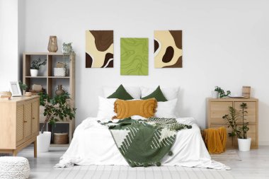 Şık yatak odaları, rahat yataklar, ev bitkileri ve güzel tablolar.