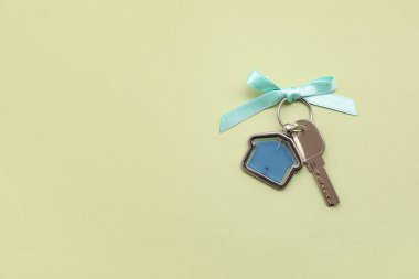 Yeşil arka planda fiyonklu evden anahtar