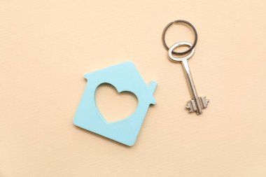 Bej arkaplanda anahtarı olan ev figürü
