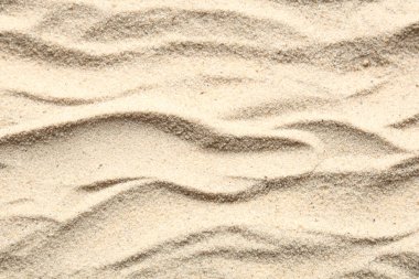 Açık bej kumsalda dalgalı kumlar. Üst görünüm