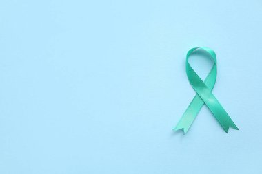 Mavi arka planda turkuaz kurdele. Rahim Sağlığı Bilinci Ayı