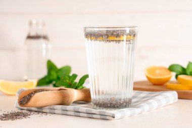 Bir bardak limon suyu, chia tohumları ve nane şekeri beyaz masada, yakın plan.