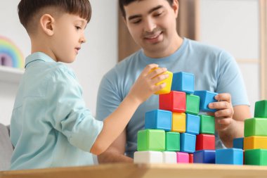 Baba ve küçük oğlu evde renkli küplerle oynuyorlar, yakın plan.