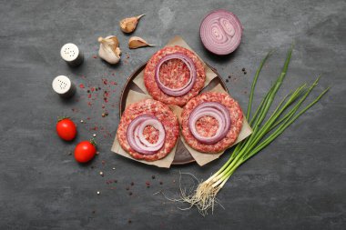 Çiğ et ve siyah arkaplanda soğan tepsisi