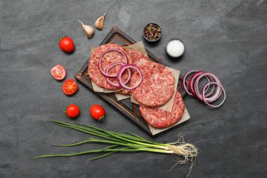 Siyah arkaplanda çiğ et dilimleri olan tepsi