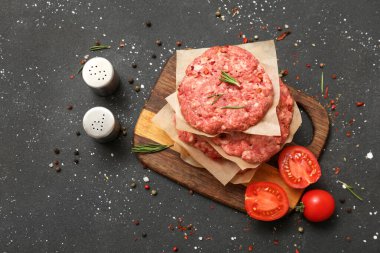 Siyah grunge arka planda çiğ et pirzolası kesme tahtası