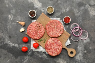 Gri grunge arka planda çiğ et pirzolası kesme tahtası