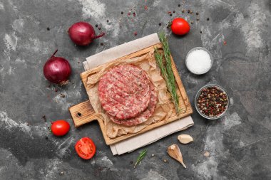 Gri grunge arka planda çiğ et pirzolası kesme tahtası