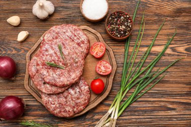 Ahşap arka planda çiğ et dilimleri ile tahta kesmek