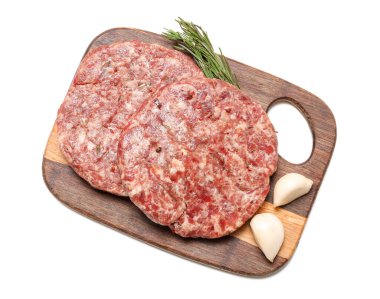 Beyaz arka planda çiğ et pirzolaları olan tahta kesme tahtası.