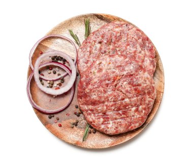 Beyaz arka planda çiğ et ve soğanlı ahşap tepsi.