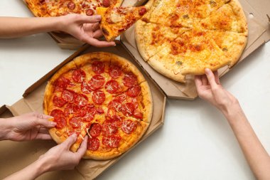 Beyaz arka planda karton pizza kutuları olan kadın eller.