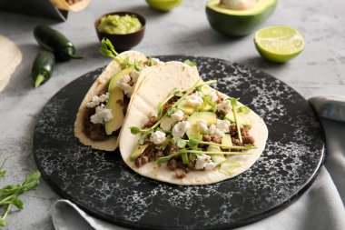 Gri arka planda lezzetli taco tepsisi, yakın plan.