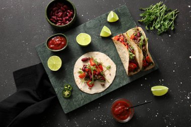 Taze takolu tepsi ve siyah benekli arka plandaki malzemeler.