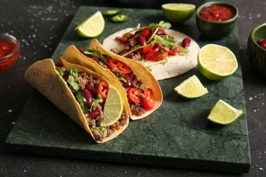 Taze takolu tepsi ve siyah benekli arka plandaki malzemeler.