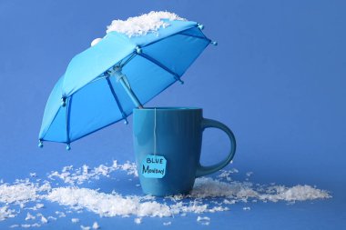Pazartesi, şemsiye ve kar içeren bardak ve çay poşeti