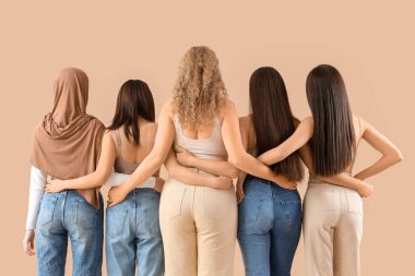 Bej arka planda sarılan bir grup genç kadın.