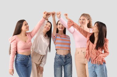 Bir grup genç kadın arka planda el ele tutuşuyorlar.