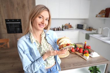 Mutfakta lezzetli tacoları olan genç bir kadın.