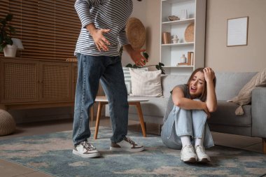 Evde kızgın kocasıyla korkmuş genç bir kadın. Aile içi şiddet kavramı