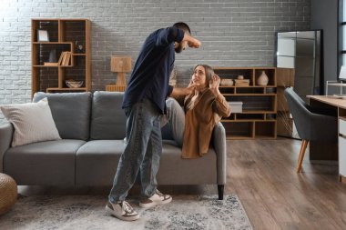 Adam evdeki kanepede karısına zarar veriyor. Aile içi şiddet kavramı