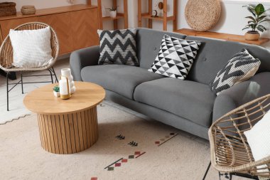 Modern koltukları, gri kanepesi ve ahşap sehpası olan şık bir oturma odası.