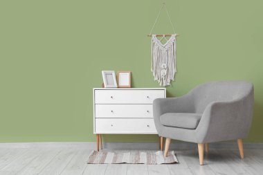 Güzel bir oturma odası, rahat gri koltuğu, çekmeceleri ve makromu var.