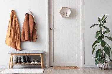 Ceketli, kapılı, gri banklı ve anahtarlı şık bir salon.