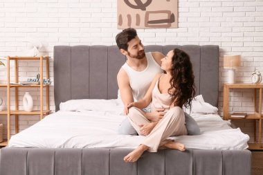 Mutlu çift yatak odasında oturuyor.