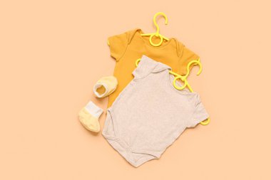 Süslü bebek kıyafetleri ve arka planda kalçaları olan askılar.