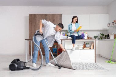 Mutfakta birlikte temizlik yapan sevimli genç bir çift.